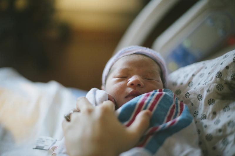 A mother holds her newborn baby in their AdventHealth hospital room