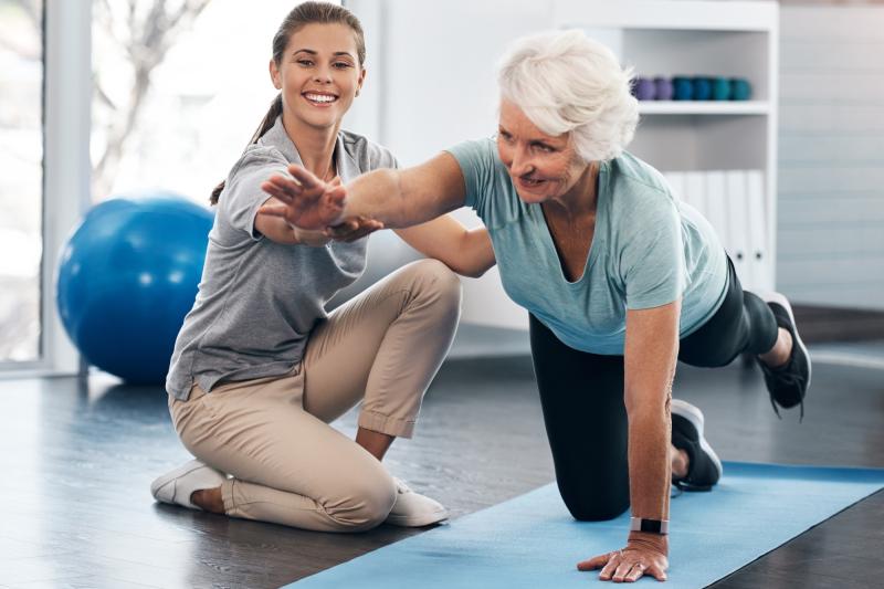 A woman works with a physical therapist.