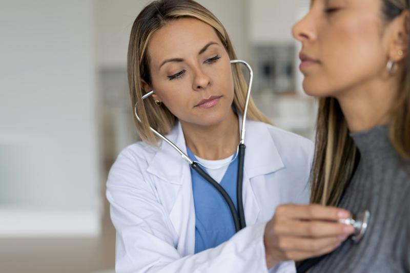 Doctor checking woman's heart