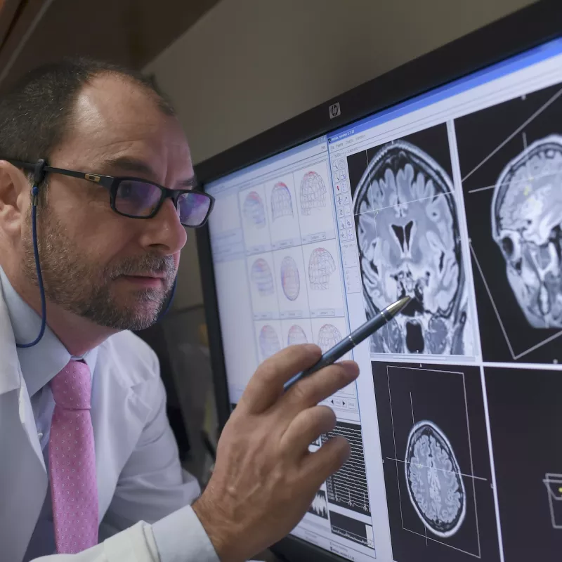 A physician reviewing MEG images on a computer monitor