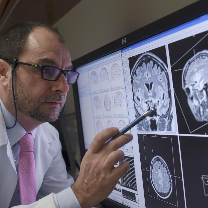 A physician reviewing MEG images on a computer monitor