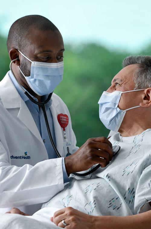Masked doctor with masked patient in Emergency Room.